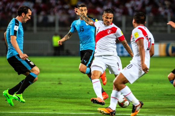 Paolo Guerrero saca el remate ante la marca de Godín. Foto: AFP