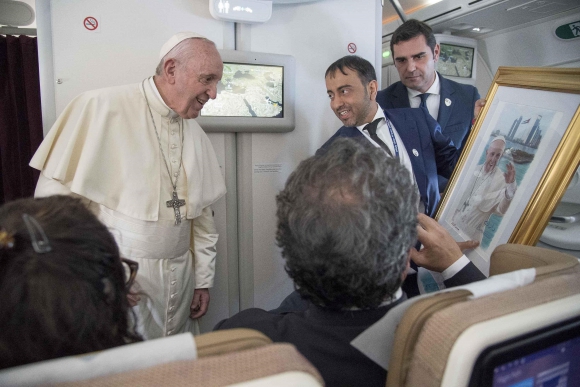 Pope Francis speaks to the media aboard the papal plane. Photo: Reuters