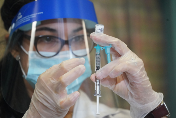 Una trabajadora de una farmacia se prepara para administrar una dosis de la vacuna desarrollada por Pfizer y BioNTech este lunes en Nueva York. Foto: AFP