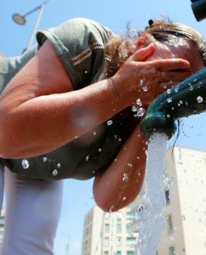 Una mujer se refresca la cara para combatir la ola de calor en Europa. Foto: Reuters